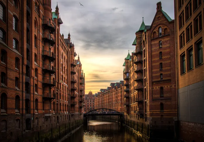 Beispiel: Foto der Speicherstadt in Hamburg, Backsteinspeicher an einem Kanal im Abendlicht, als Poster mit weißem Rand im Rahmen Eiche natur